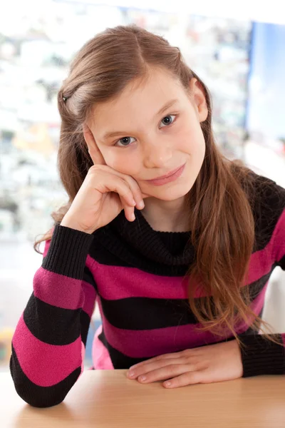 Mädchen denkt, während sie am Schreibtisch sitzt — Stockfoto