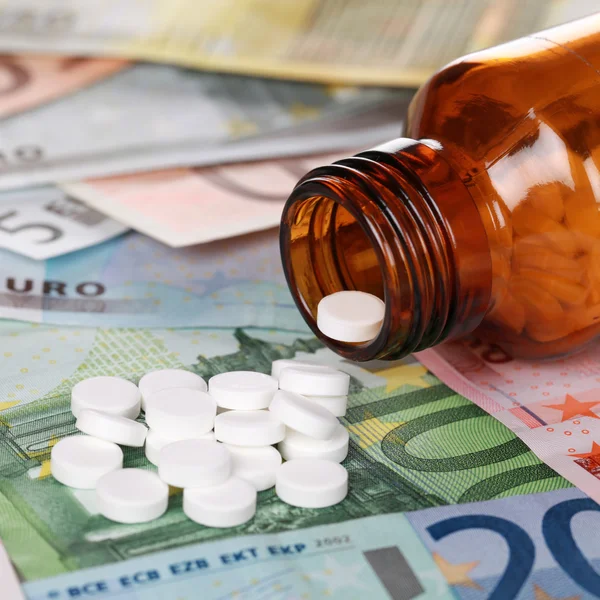 Высокая стоимость медицинского обслуживания с лекарствами на банкнотах евро — стоковое фото