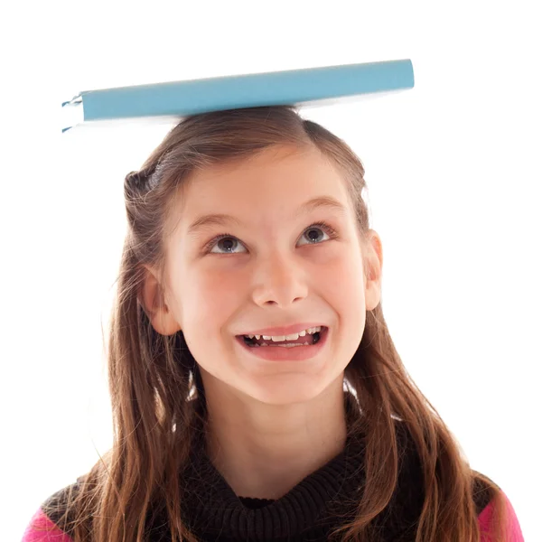 Meisje balancing een boek over haar hoofd — Stockfoto