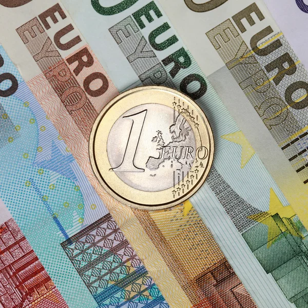 Ein-Euro-Münze auf Banknoten — Stockfoto