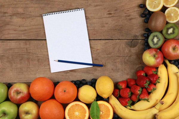 Frutas en una tabla de madera con cuaderno —  Fotos de Stock