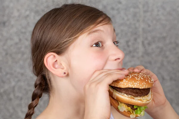 Menina comendo um hambúrguer — Fotografia de Stock