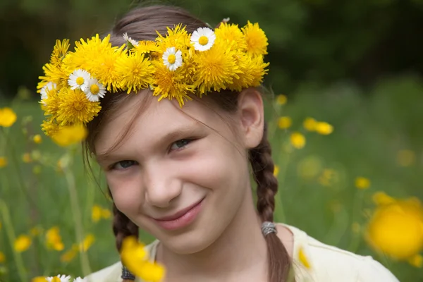 Девушка с цветами на голове на лугу в природе — стоковое фото