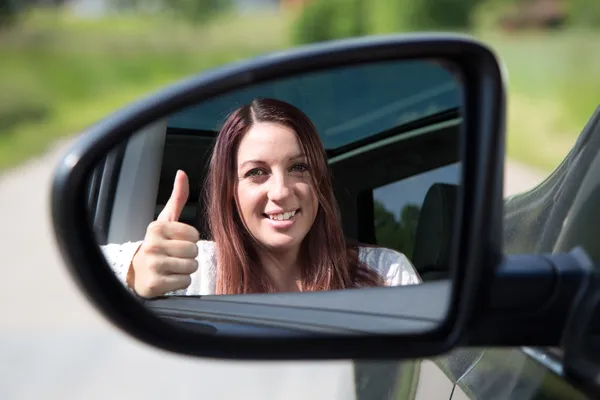 Happy driver showing thumbs up in the mirror — Stock Photo, Image