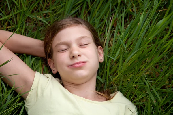 Menina deitada em um prado na natureza — Fotografia de Stock