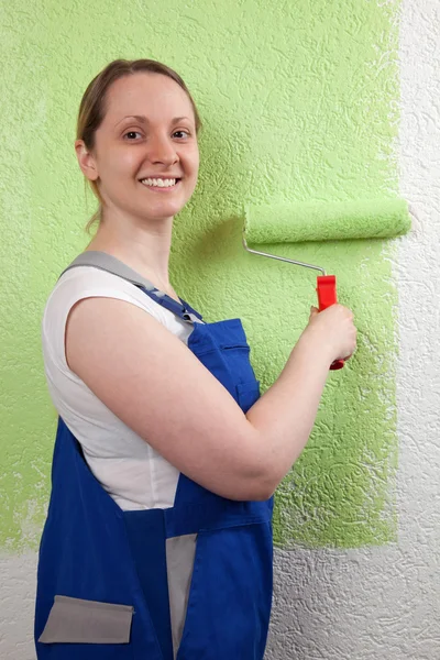 Młoda kobieta maluje ścianę — Zdjęcie stockowe