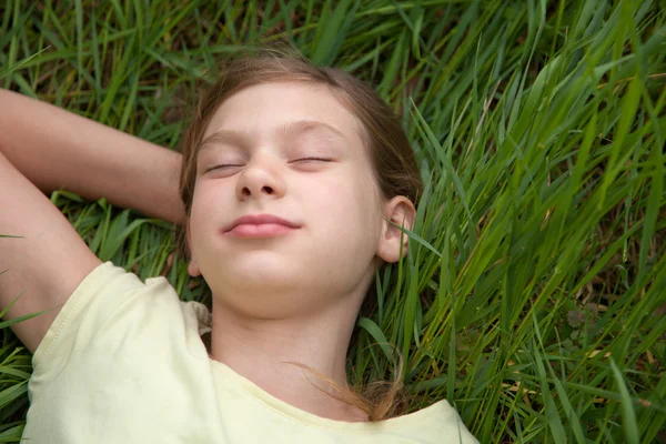 Child lying on a green meadow — Stock Photo, Image