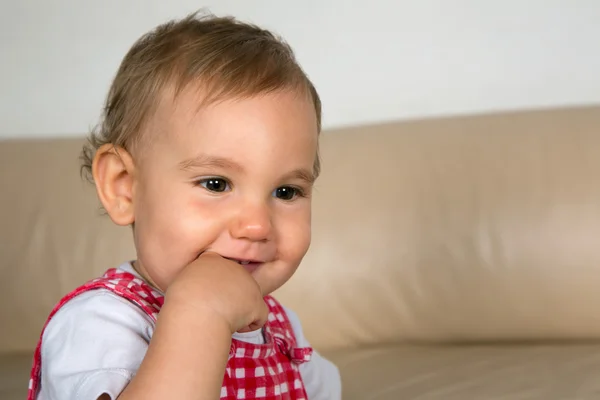 Lächelndes Baby mit dem Finger im Mund — Stockfoto