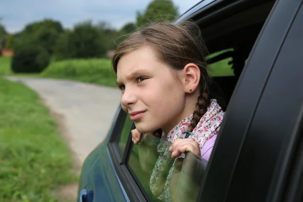 Niña mirando por la ventana de un coche — Foto de Stock