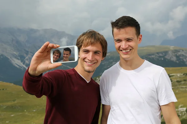 Vänner att ta bilder med en smartphone på semester — Stockfoto