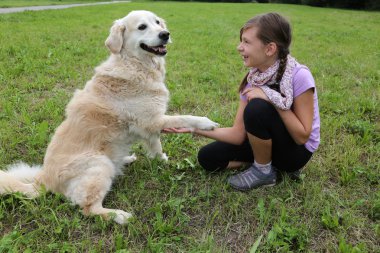 bir kız ile el sıkışan köpek