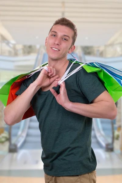 Joven con bolsas de compras en un centro comercial —  Fotos de Stock