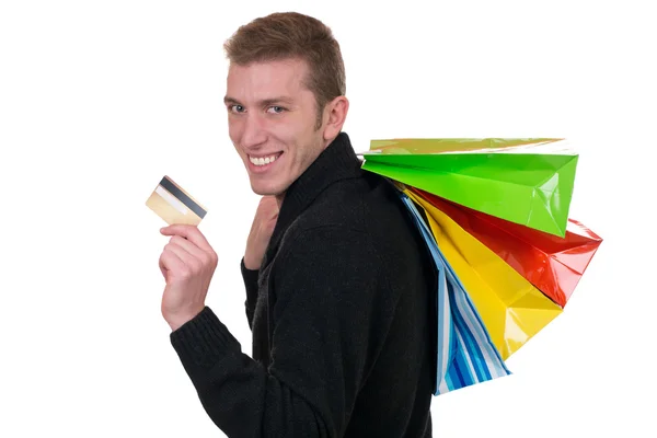 Homme souriant avec carte de crédit et sacs à provisions — Photo