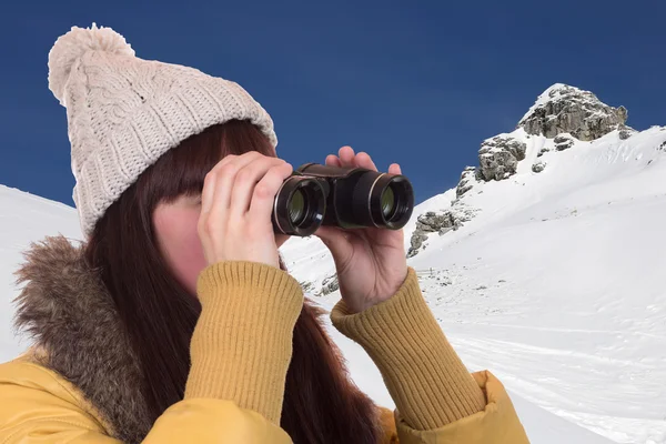 Giovane donna che guarda attraverso il binocolo in montagna — Foto Stock