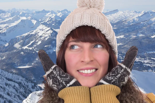 Šťastná žena s rukavice a čepici v horách — Stock fotografie
