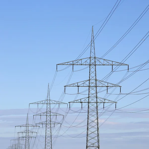 Strommasten vor blauem Himmel Thema Energie und Strom — Stok fotoğraf