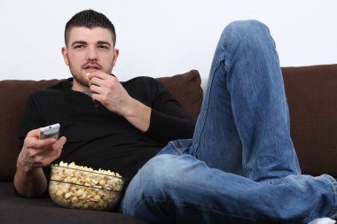 TV izlerken, patlamış mısır yemek genç adam