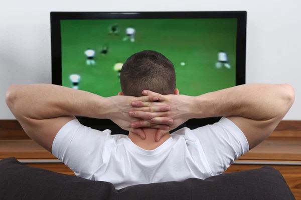 テレビでサッカーを見て若い男 — ストック写真