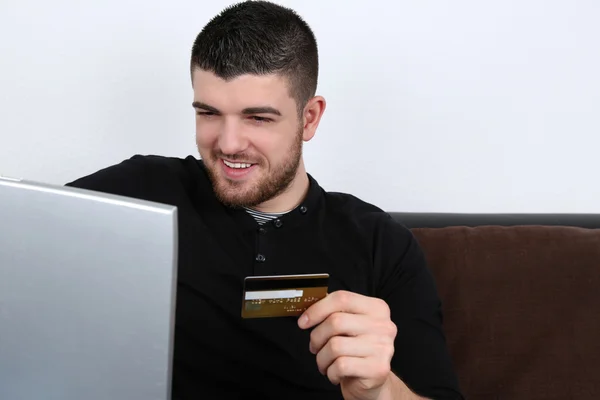 Młody człowiek za pomocą laptopa za zakupy w Internecie — Zdjęcie stockowe