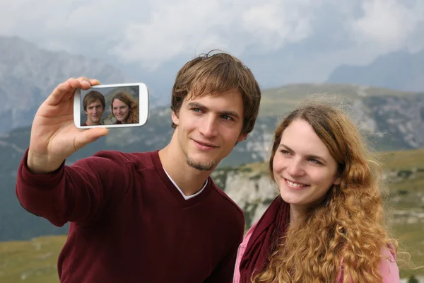 Tomar fotos con un smartphone durante las vacaciones en la montaña — Foto de Stock