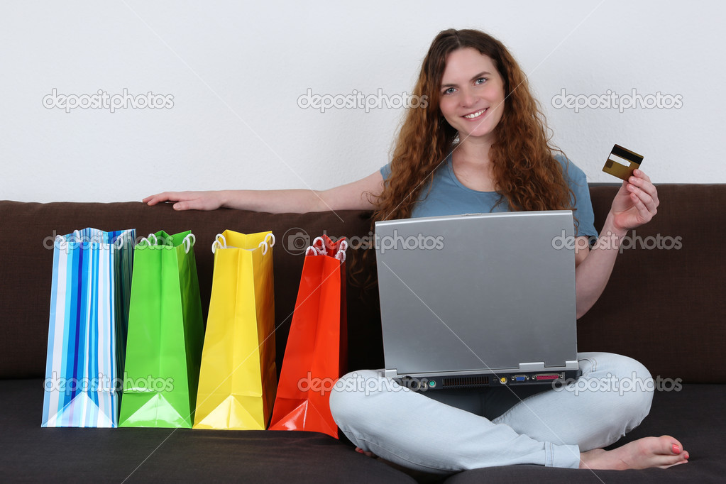 Young woman with laptop computer doing internet shopping