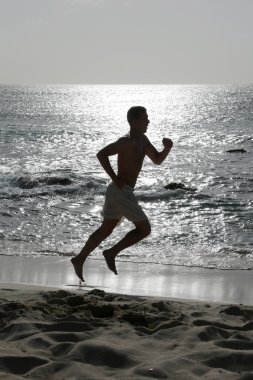 genç adam çalıştıran veya sahilde koşu
