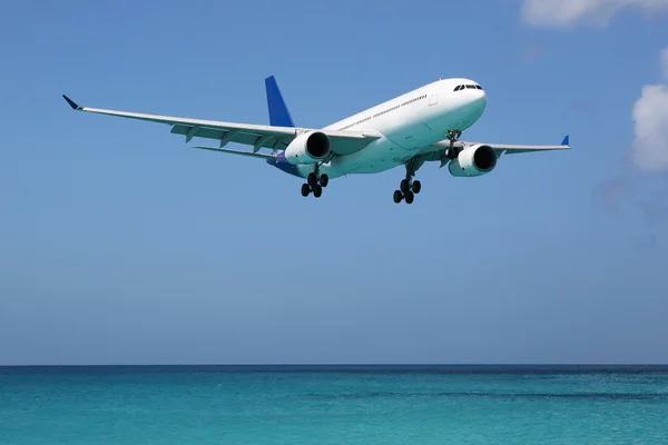 Airplane landing over the sea on vacation — Stock Photo, Image