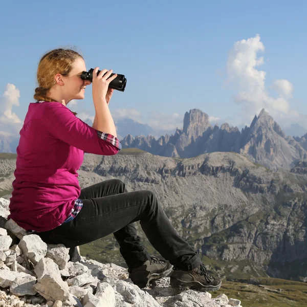 Mladá žena sleduje krajina v horách — Stock fotografie