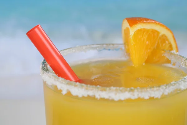Primer plano zumo de naranja fresco en vaso en la playa — Foto de Stock