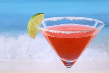 Kırmızı martini ile sahilde bir kireç kokteyl