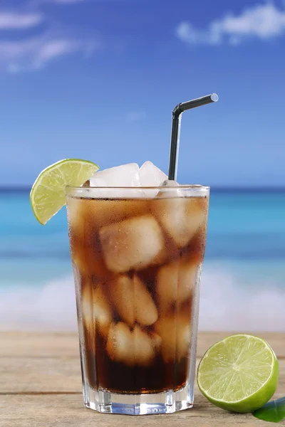 Cola en vidrio con cal en la playa —  Fotos de Stock