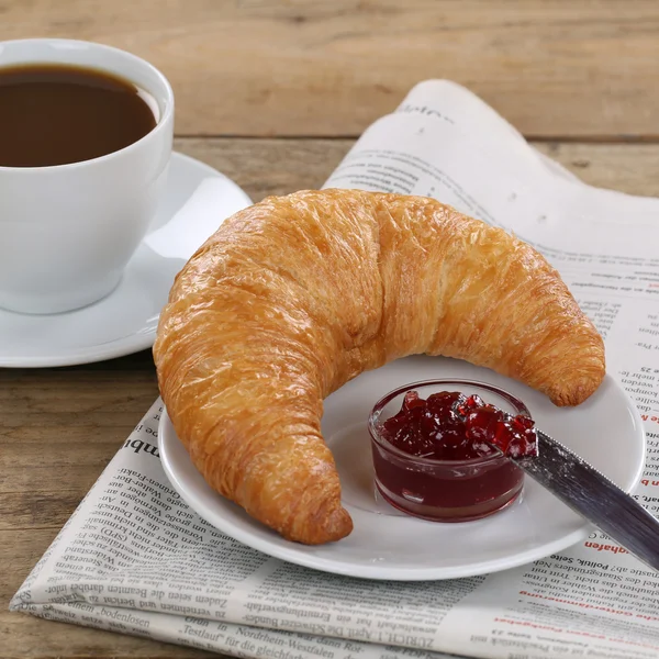 Business breakfast with croissant, coffee and newspaper — Stock Photo, Image