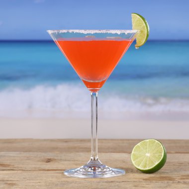 Kırmızı kokteyl martini içmek sahilde