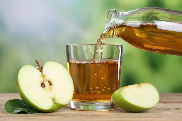 Zumo de manzana vertido de manzanas verdes en un vaso — Foto de Stock