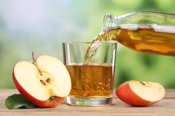 Jus de pomme versé des pommes rouges dans un verre — Photo