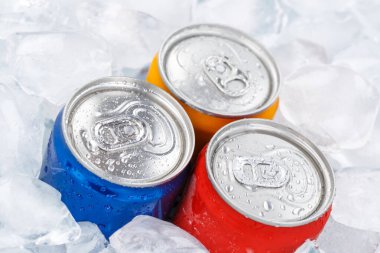 Limonata kola içer. Kutularda meşrubat içer.