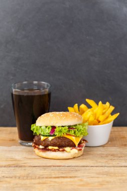 Hamburger, çizburger, fast food, kola ve tahtadan yapılmış portre şeklinde patates kızartması.
