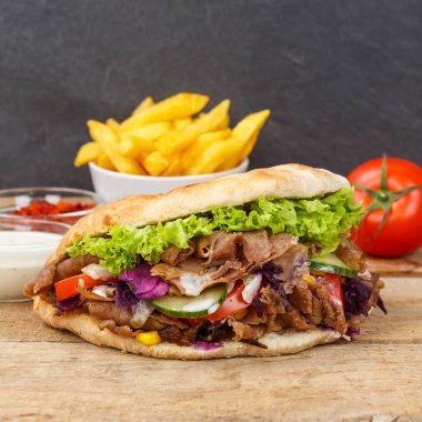 Kebab Doner Kebap Flatbread 'de fast food ve tahtadan yapılmış kare atıştırmalık patates kızartması.