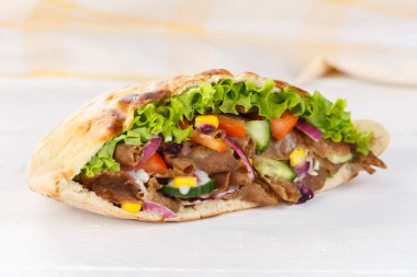 Kebapçı Doner Kebap tahtadan dilimlenmiş ekmeğin içinde fast food dilimliyor.