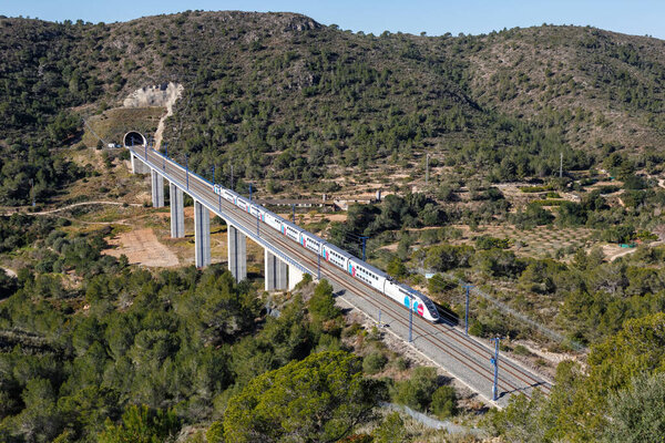 Roda de Bera, Spain - February 20, 2022 TGV Euroduplex high-speed train of Ouigo Espana SNCF on the Madrid - Barcelona high speed railway line near Roda de Bera in Spain.