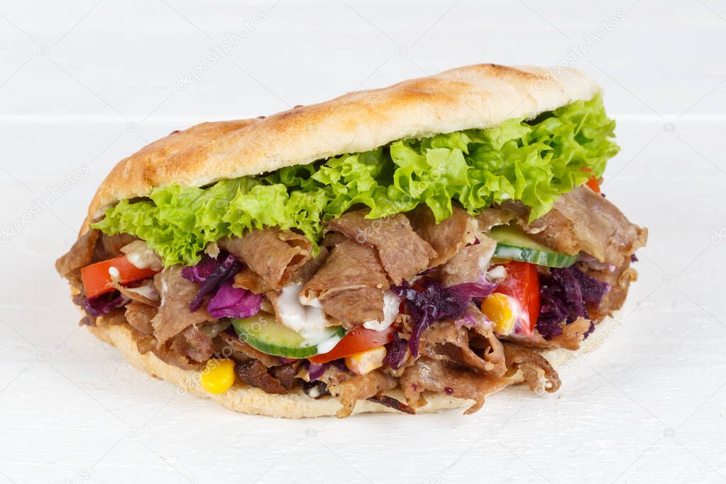 Kebab Doner Kebap slice fast food in flatbread on a wooden board sliced
