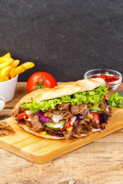 Doner Kebap Doner Flatbread Flatbread 'de hazır yemek ve tahtadan yapılmış patates kızartması.