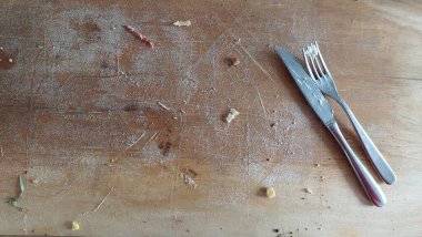 Tahta arka planda çatal ve bıçak olan boş bir tabak.