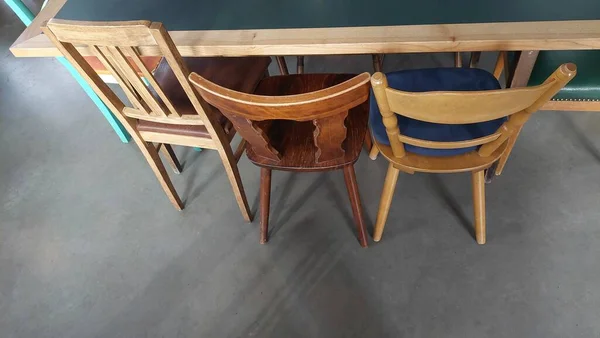 Lege Stoelen Een Rij Een Houten Tafel — Stockfoto