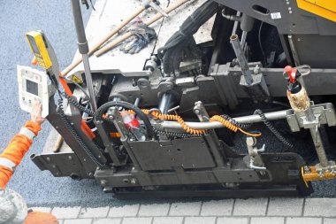 Yolda yeni asfalt yüzeyi oluşturan makine