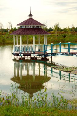 Suyun üstünde köprüsü ve parmaklıkları olan nefis bir çardak.