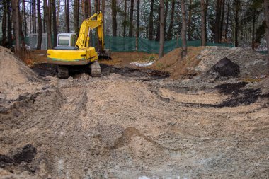 Kazıcı kırsalda bir inşaat alanında çalışıyor.