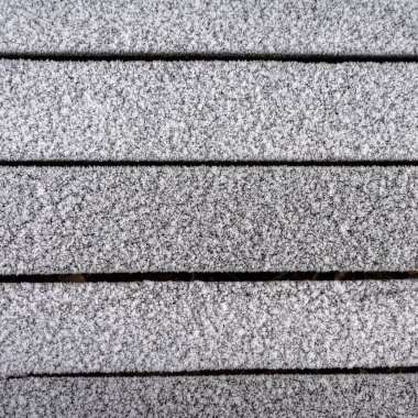 Soğuk bir sabahta beyaz buzla kaplı ahşap bir duvar..