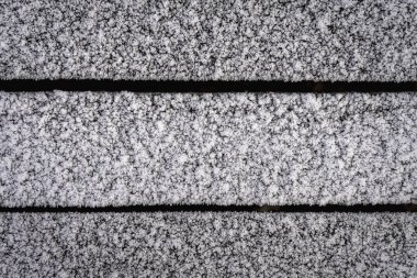 Soğuk bir sabahta beyaz buzla kaplı ahşap bir duvar..