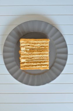 Piece of Honey Cake with two layers of pear marmalade on a gray plate